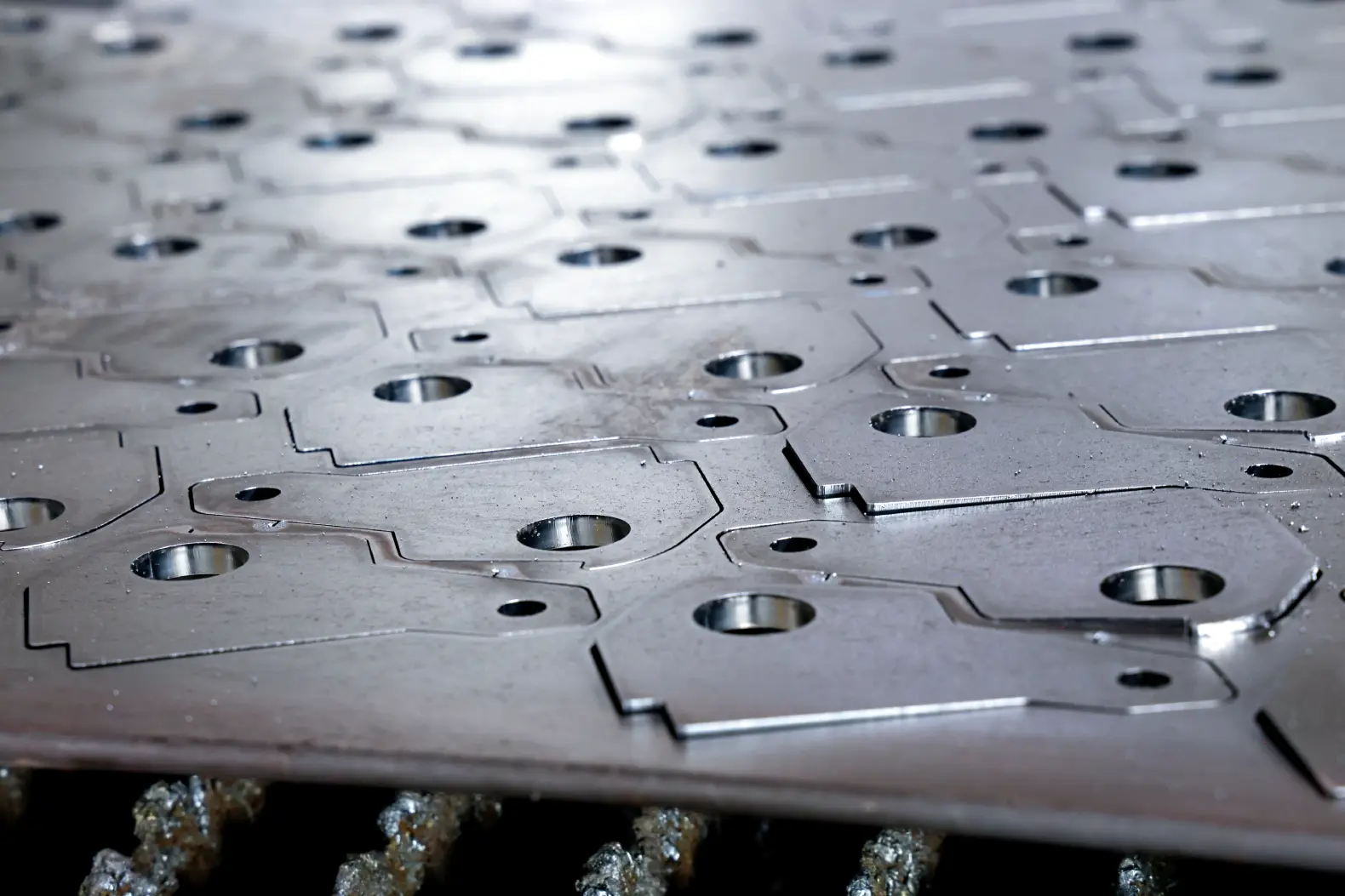 Laser-cut steel parts still nested in the sheet, straight off the cutting bed