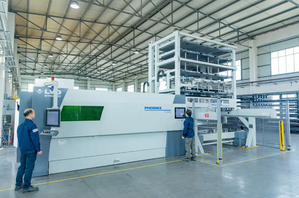 Operators running a fiber laser cutting machine with automatic sheet tower at Boda